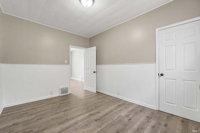 1743 Franklin Ave, Fort Wayne, IN 46808 - empty room featuring ornamental molding, wainscoting, wood finished floors, and visible vents
