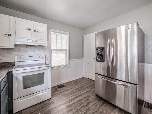 kitchen featuring white range with electric stovetop, dark wood-type flooring, under cabinet range hood, stainless steel refrigerator with ice dispenser, and visible vents