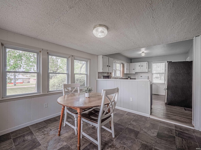 dining area with baseboards and a textured ceiling