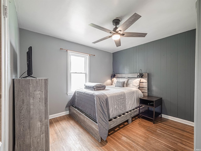 bedroom with baseboards, ceiling fan, and light wood-style flooring