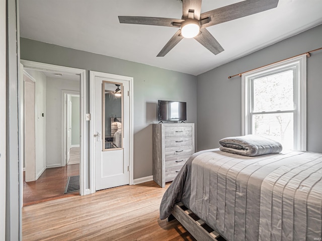 bedroom with baseboards, visible vents, ceiling fan, and light wood finished floors