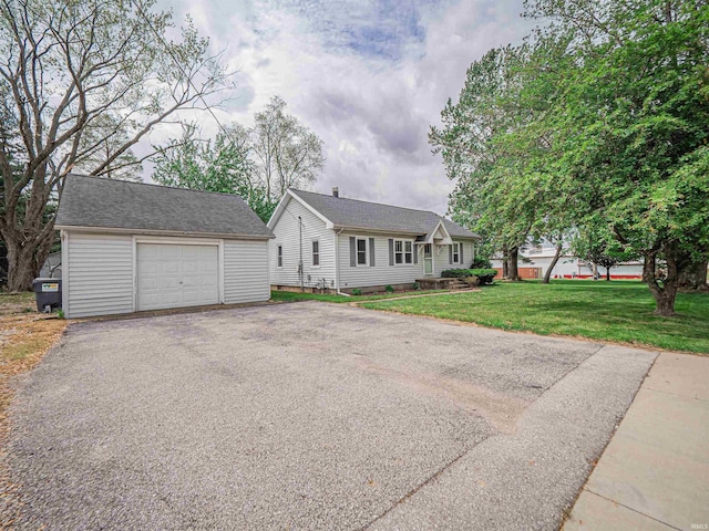view of front facade with an outdoor structure, aphalt driveway, a front yard, and a detached garage
