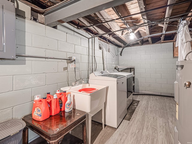 clothes washing area with laundry area, light wood-style flooring, washer and dryer, and electric water heater