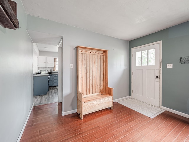 entryway featuring baseboards and wood finished floors