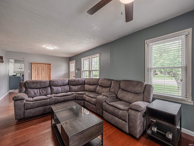 living room with baseboards, ceiling fan, and wood finished floors