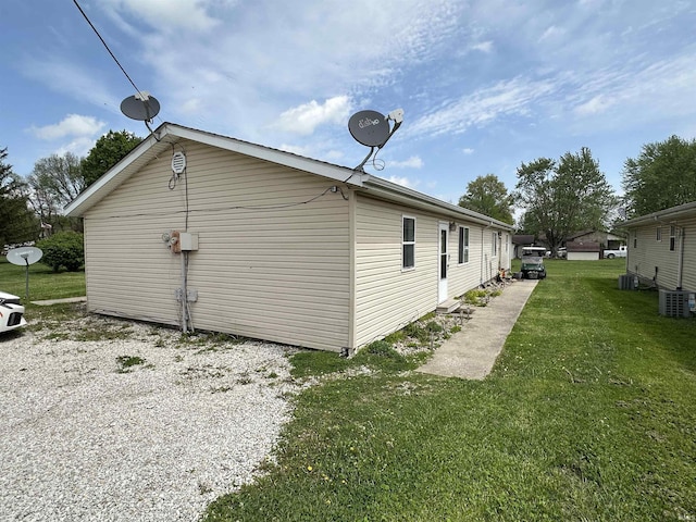 view of side of home with a lawn and central air condition unit