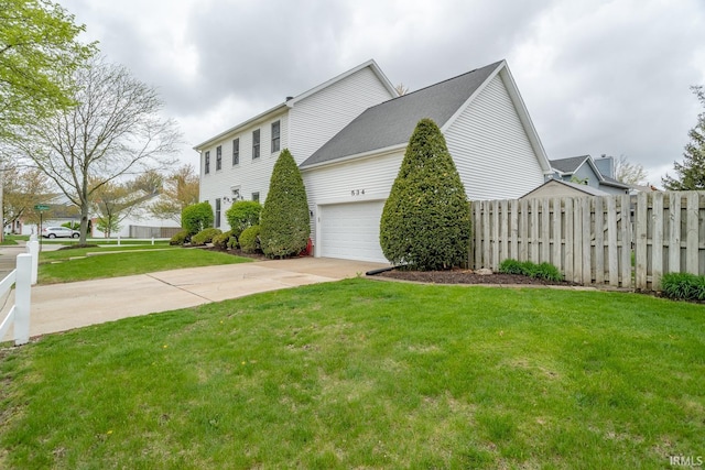 534 Lagrange St, West Lafayette, IN 47906 - view of side of property with a lawn, fence, concrete driveway, and a garage