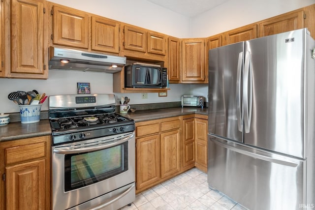534 Lagrange St, West Lafayette, IN 47906 - kitchen featuring appliances with stainless steel finishes, under cabinet range hood, brown cabinets, and dark countertops