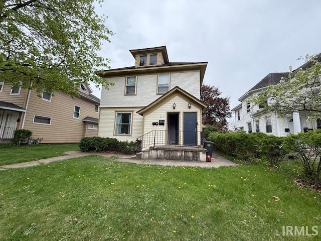back of property with a lawn