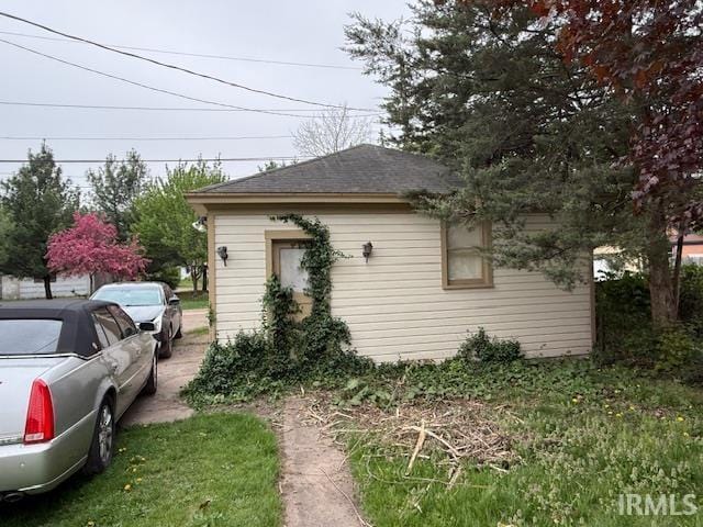 view of side of property featuring roof with shingles