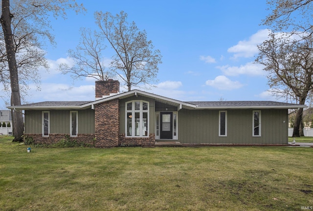 view of front of property with brick siding, a front lawn, and a chimney