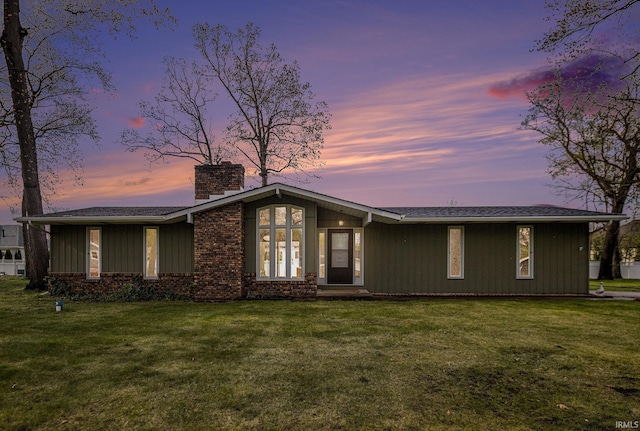 mid-century home with a lawn and a chimney
