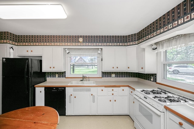 kitchen featuring a sink, white cabinetry, and black appliances