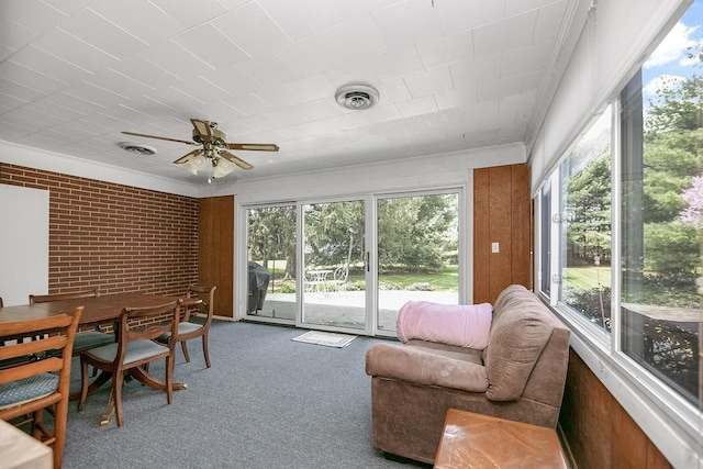 sunroom featuring visible vents, carpet flooring, a wealth of natural light, and ornamental molding