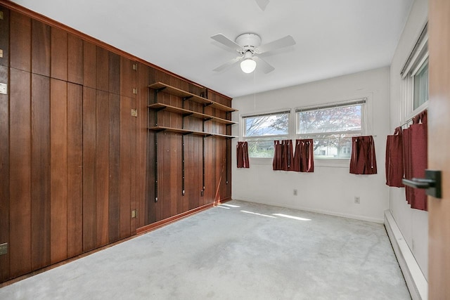 spare room with baseboards, a baseboard radiator, a ceiling fan, and light carpet