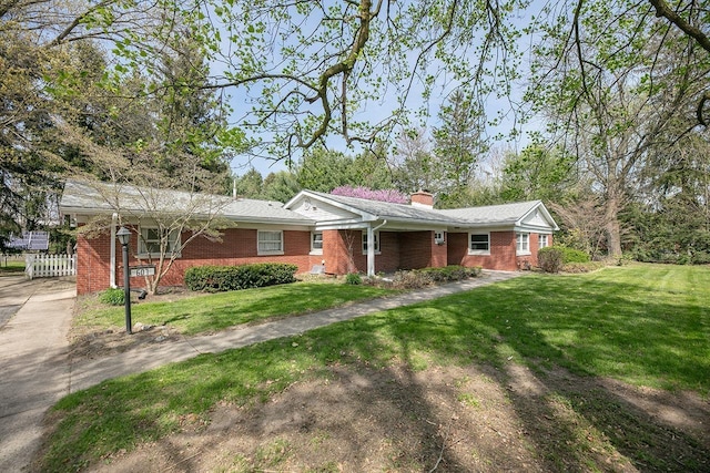 ranch-style home with fence, a chimney, a front lawn, and brick siding