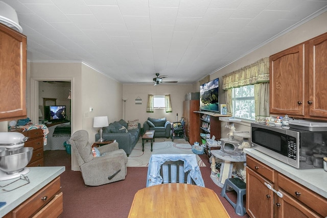carpeted living room featuring crown molding and ceiling fan