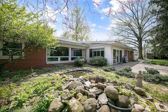 view of home's exterior featuring brick siding and a patio area