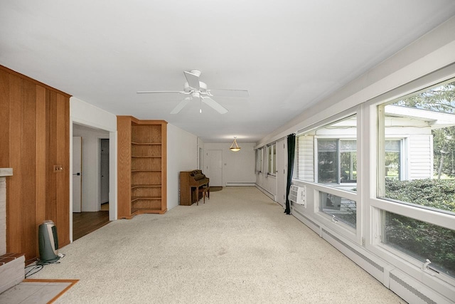 unfurnished living room with wooden walls, ceiling fan, and light colored carpet