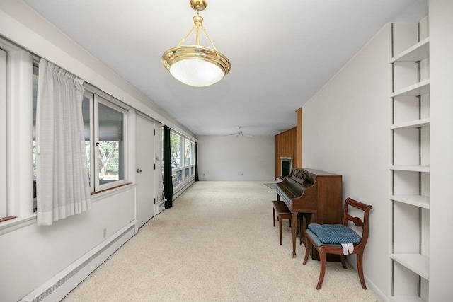 living area with a ceiling fan, a large fireplace, carpet, and a baseboard heating unit