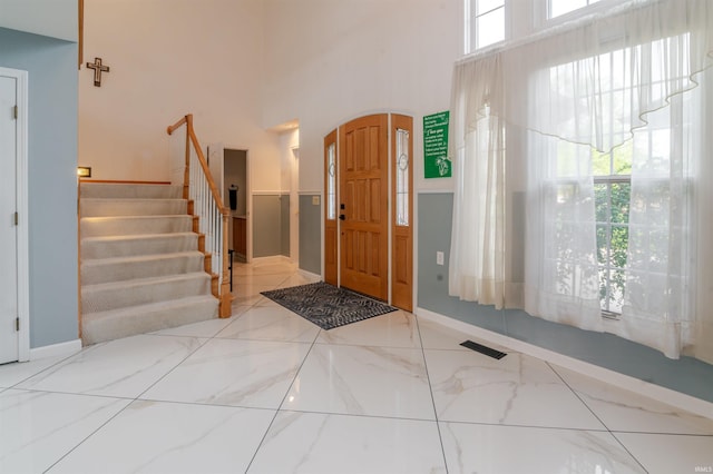 68106 Telegraph Ct, Lakeville, IN 46536 - foyer entrance featuring visible vents, marble finish floor, stairs, and a towering ceiling