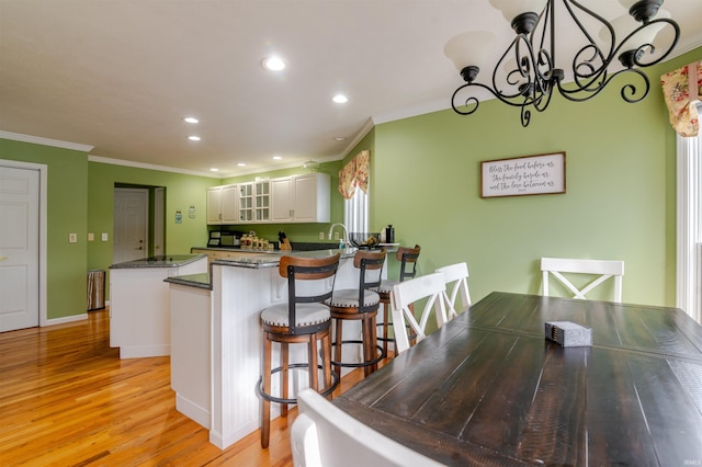 68106 Telegraph Ct, Lakeville, IN 46536 - kitchen with light wood-type flooring, a peninsula, ornamental molding, recessed lighting, and white cabinetry