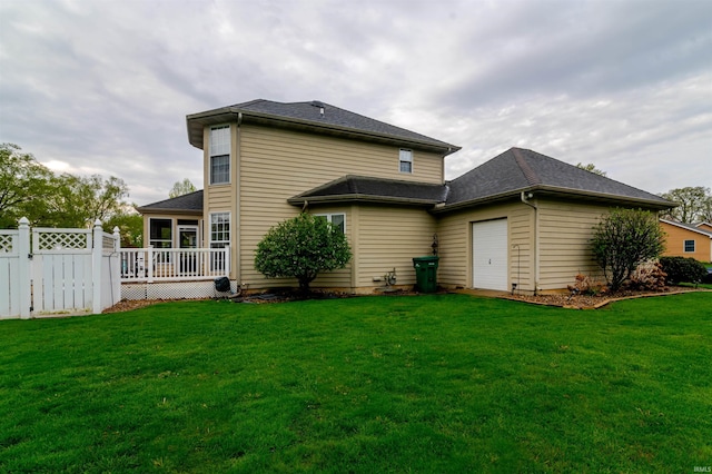 68106 Telegraph Ct, Lakeville, IN 46536 - rear view of house with a sunroom, an attached garage, a lawn, and fence