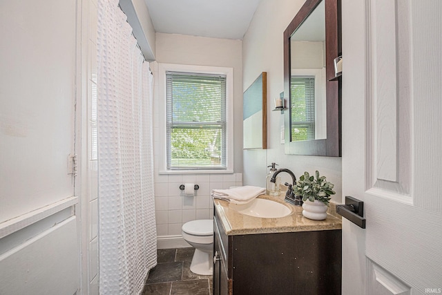 full bathroom with vanity, a shower with curtain, toilet, and stone finish flooring
