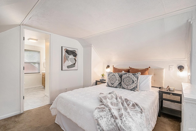 carpeted bedroom featuring baseboards, ensuite bathroom, a textured ceiling, and lofted ceiling