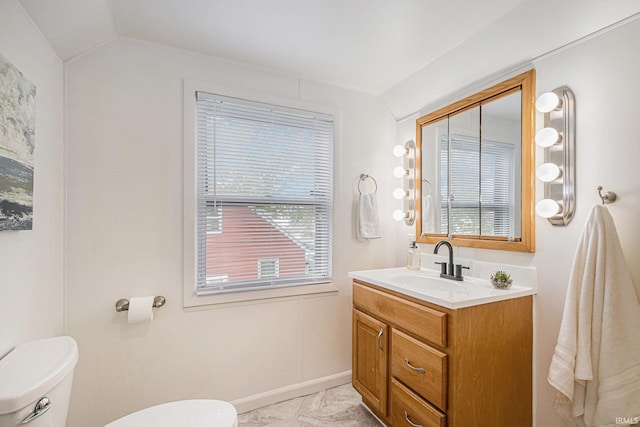half bathroom with vanity, baseboards, toilet, and lofted ceiling