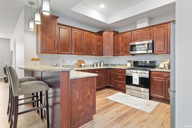 54637 Burdette St Unit 2, South Bend, IN 46637 - kitchen featuring light wood-type flooring, a peninsula, and appliances with stainless steel finishes