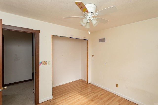 unfurnished bedroom with visible vents, light wood-style flooring, baseboards, and a closet