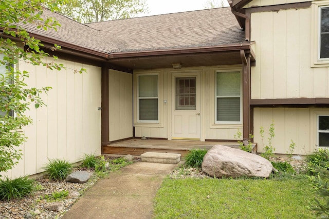 view of exterior entry featuring a shingled roof