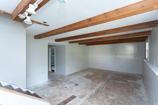 unfurnished room with unfinished concrete flooring and beam ceiling