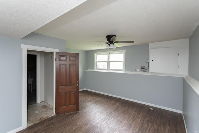 empty room featuring baseboards, ceiling fan, a textured ceiling, and wood finished floors