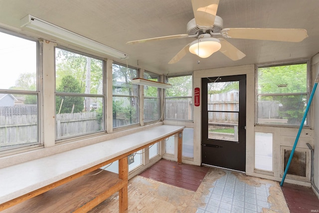 unfurnished sunroom with ceiling fan
