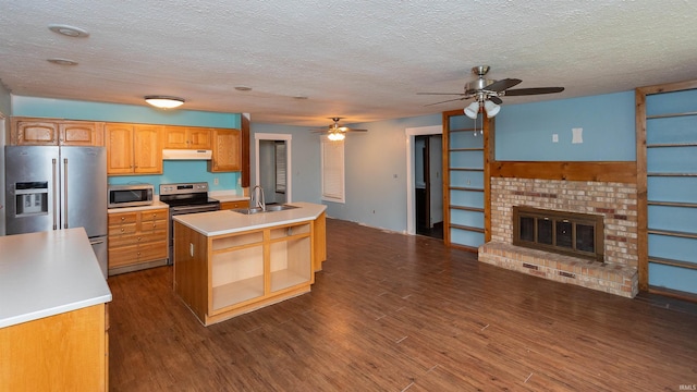 kitchen with a ceiling fan, light countertops, under cabinet range hood, a sink, and stainless steel appliances