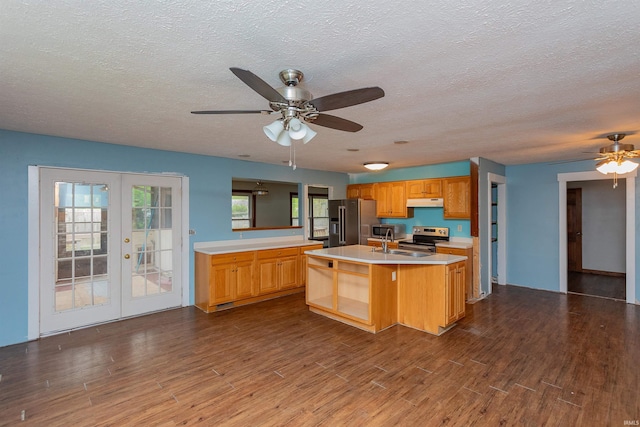 kitchen with appliances with stainless steel finishes, light countertops, french doors, a ceiling fan, and under cabinet range hood