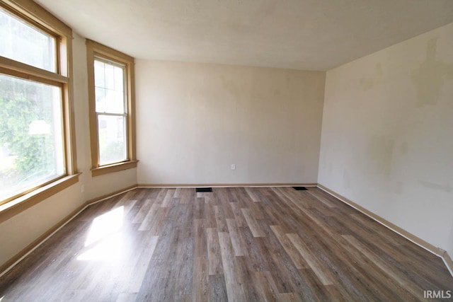 2813 W Franklin St, Evansville, IN 47712 - empty room with baseboards, plenty of natural light, wood finished floors, and visible vents