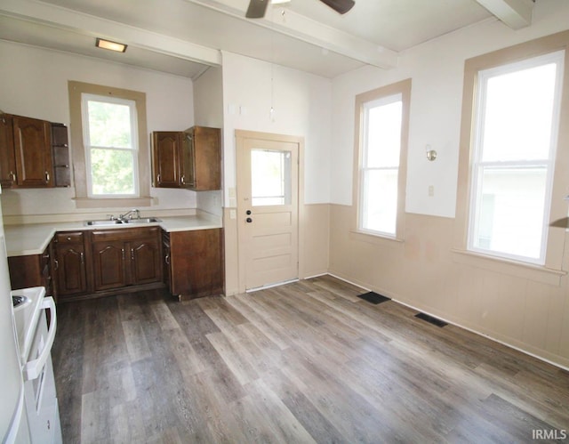 2813 W Franklin St, Evansville, IN 47712 - kitchen with a sink, stove, wood finished floors, and beamed ceiling