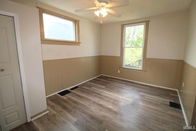 2813 W Franklin St, Evansville, IN 47712 - spare room featuring ceiling fan, visible vents, wood finished floors, and a wainscoted wall