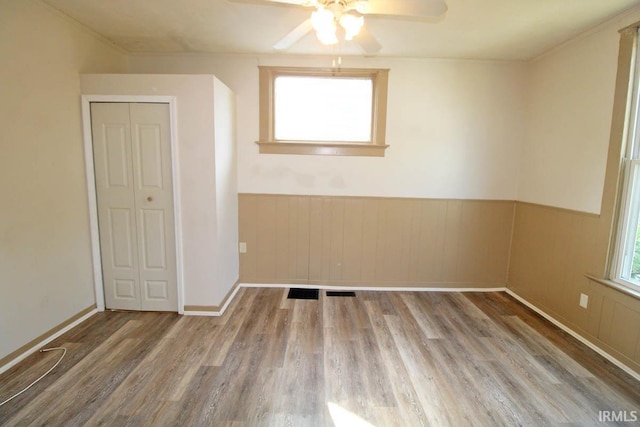 2813 W Franklin St, Evansville, IN 47712 - empty room with ceiling fan, wainscoting, and wood finished floors