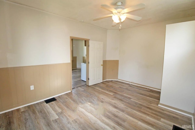 2813 W Franklin St, Evansville, IN 47712 - spare room with a ceiling fan, baseboards, wood finished floors, and a wainscoted wall
