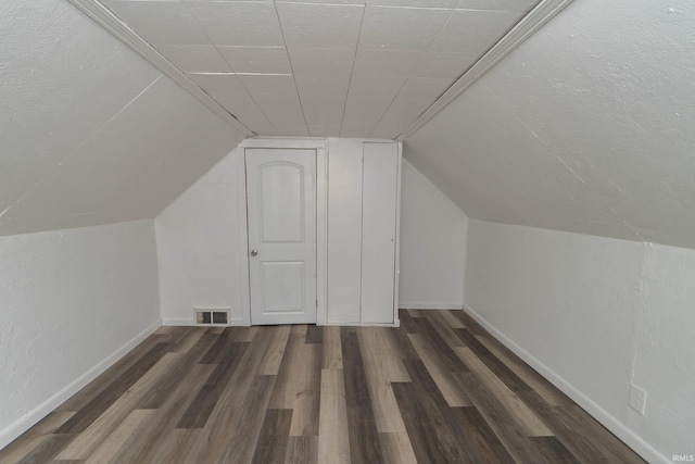 bonus room with lofted ceiling, wood finished floors, and visible vents