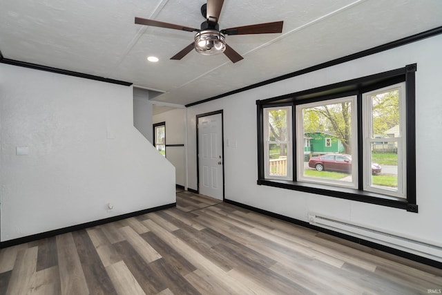 unfurnished living room featuring ornamental molding, baseboards, baseboard heating, recessed lighting, and a ceiling fan