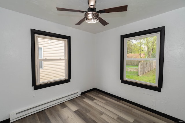unfurnished room with a ceiling fan, a baseboard heating unit, and wood finished floors