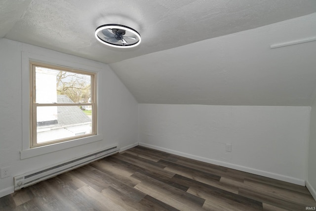 additional living space featuring baseboards, a baseboard radiator, vaulted ceiling, and dark wood-style floors
