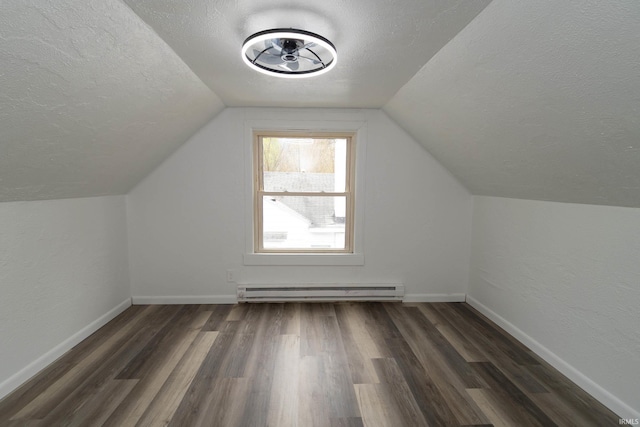 bonus room with a textured ceiling, baseboard heating, vaulted ceiling, baseboards, and dark wood-style floors