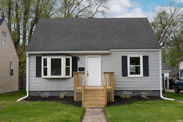 new england style home with a front lawn and roof with shingles