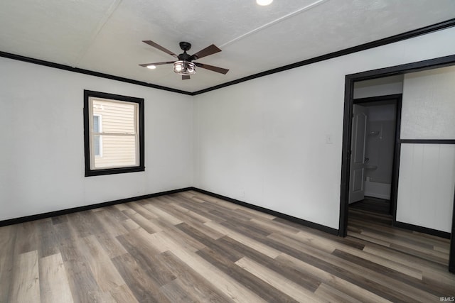 unfurnished bedroom featuring crown molding, baseboards, a ceiling fan, and wood finished floors